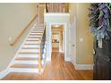 Inviting foyer with hardwood floors, staircase, and a view into the kitchen, with a decorative wreath at 5020 Huntshire Sw Ln, Lilburn, GA 30047