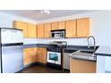 Efficient kitchen boasts stainless appliances, light wood cabinets, and sleek countertops at 115 W Peachtree Nw Pl # 709, Atlanta, GA 30313