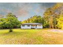 Inviting single-story home with a white porch, surrounded by a lush green lawn and mature trees at 4665 Jersey Walnut Grove Rd, Covington, GA 30014