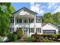 Traditional two-story home with a white brick facade, black shutters, and lush landscaping at 731 Sacketts Ct, Lawrenceville, GA 30043