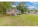 Quaint single-story home with a large front lawn and a vibrant orange front door at 992 Estes Sw Dr, Atlanta, GA 30310