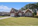 Beautiful single-Gathering home featuring a brick facade, attached garage, and large front lawn in a suburban setting at 1180 Chandler Ridge Dr, Lawrenceville, GA 30045