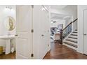 Bright foyer with staircase, powder room, and views into the adjacent living area at 2142 Arnage Dr, Lithonia, GA 30058