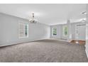 Spacious living room featuring neutral carpet, paint, and large windows at 110 Village Green Cir, Tyrone, GA 30290