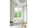 Close-up of a kitchen showcasing a modern sink, gold faucet, sleek countertops, stylish backsplash, and stainless steel gas range at 11548 Serenbe Ln, Chattahoochee Hills, GA 30268