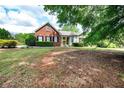 Beautiful brick home featuring mature trees and an expansive front yard at 1510 Pecan Plantation Ct, Loganville, GA 30052