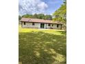 Expansive backyard featuring a well-maintained lawn, mature trees, and a neutral toned patio area at 4074 Green Hawk Trl, Decatur, GA 30035