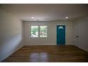 Bright living room with hardwood floors, a large window, and a vibrant blue door that adds a pop of color at 4074 Green Hawk Trl, Decatur, GA 30035