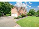 Two-car garage and pristine landscaping highlighting the exterior of this stately brick home at 1430 Hampton Hill Dr, Alpharetta, GA 30022