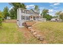 View of home and landscaped side yard with retaining wall at 565 Deer Sw Run, Lilburn, GA 30047