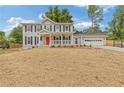 Charming two-story home with a bright red front door and covered porch at 565 Deer Sw Run, Lilburn, GA 30047