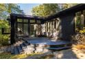 View of the outdoor deck area with black painted stairs and siding with many windows at 922 Barton Woods Ne Rd, Atlanta, GA 30307