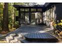 View of the outdoor deck area with black painted stairs and siding with door and windows at 922 Barton Woods Ne Rd, Atlanta, GA 30307