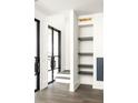 Modern entryway featuring custom iron doors, hardwood floors, and built-in shelving at 11554 Serenbe Ln, Chattahoochee Hills, GA 30268