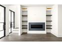 Bright living room with a modern fireplace and custom built-in shelving at 11554 Serenbe Ln, Chattahoochee Hills, GA 30268