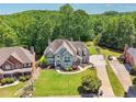 A beautiful home with a well manicured yard and basketball court; surrounded by lush trees at 2645 Preston Ridge Ln, Dacula, GA 30019