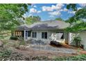 Back exterior featuring an enclosed porch and natural landscaping at 3003 Heavenly Ln, Snellville, GA 30078