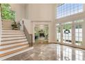 Bright foyer boasts high ceilings, large windows, tile floors, and staircase with wood treads and modern railing at 310 Tradea Tarn, Roswell, GA 30076