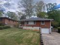 Charming brick home featuring an attached single-car garage and well-maintained front lawn at 1230 Lloyd Dr, Forest Park, GA 30297