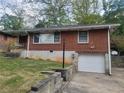 Charming brick home featuring an attached single-car garage and well-maintained front lawn at 1230 Lloyd Dr, Forest Park, GA 30297