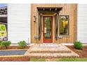 Charming home entrance with a red door, brick steps, and craftsman-style wood accents at 12520 Celestine Way, Milton, GA 30075