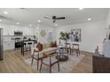 Sun-filled living room featuring modern decor, a ceiling fan, and an open layout to the kitchen at 3634 Oakleaf Pass, Fairburn, GA 30213