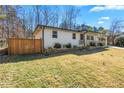Side view of a well-maintained white home with wooden fence and green lawn at 5109 Dogwood Hills Dr, Sugar Hill, GA 30518