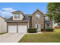 Charming brick two-story home with attached two-car garage and green lawn at 4207 Fortune Pt, South Fulton, GA 30349