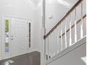 Bright foyer featuring white walls, a staircase with wooden railing, and a front door with sidelights at 4353 Pond Edge Rd, Snellville, GA 30039