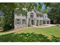 Elegant two-story home with gray brick, black shutters, and a lush green lawn surrounded by trees at 5702 Brynwood Nw Cir, Acworth, GA 30101