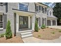 Stately gray brick home showcasing a welcoming front entrance with a double door entry and manicured landscaping at 5702 Brynwood Nw Cir, Acworth, GA 30101