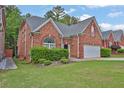 View of the side of a red brick home with lush green lawn and tidy landscaping at 735 Scenic Creek Dr, Lawrenceville, GA 30046
