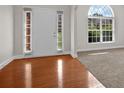 Bright foyer with hardwood flooring transitioning to carpet, flanked by sidelight windows at 735 Scenic Creek Dr, Lawrenceville, GA 30046