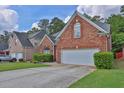 Well-maintained red brick home featuring a two-car garage and mature landscaping at 735 Scenic Creek Dr, Lawrenceville, GA 30046