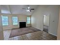 Bright living room featuring high ceilings, a fireplace, and tiled floors with neutral-colored walls at 7518 Edenberry Way, Lithonia, GA 30058
