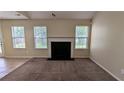 Open living room with a fireplace, neutral paint, and carpet, offering a cozy atmosphere at 7518 Edenberry Way, Lithonia, GA 30058