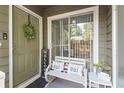 Inviting front porch with a charming welcome sign, a bench with pillows and decorative wreath at 1106 Rock Creek Ln, Norcross, GA 30093
