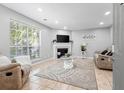 Well-lit living room featuring a fireplace, a large window, and comfortable neutral furniture at 1106 Rock Creek Ln, Norcross, GA 30093
