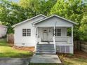 Quaint home featuring a covered front porch, white siding, and neat landscaping for a cozy curb appeal at 1596 Foote Ne St, Atlanta, GA 30307