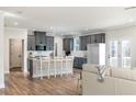Modern kitchen with gray cabinets, a center island with bar stools, stainless steel appliances, and hardwood floors at 3686 Bills Cir, Atlanta, GA 30331