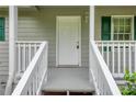 Inviting front entrance with white railings and a white door flanked by dark green shutters and matching trim at 4855 Brownsville Rd, Powder Springs, GA 30127