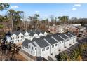 Aerial view showcasing a community of modern townhomes with garages and pristine landscaping at 308 Chardonnay Way, Woodstock, GA 30188