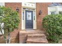 Inviting front entrance features a leaded glass door with sidelights, sconces, and brick steps at 3761 Bays Ferry Way, Marietta, GA 30062