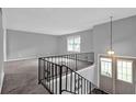 Open living space with carpet, gray walls, and stylish railings leading to the entryway at 3929 Emerald Springs Ct, Decatur, GA 30035
