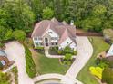 Aerial view of the property showcasing the home, manicured lawn, and surrounding trees at 1008 Stream Valley Ct, Alpharetta, GA 30022