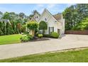 View of the side of the home showcasing a driveway and manicured landscaping at 1008 Stream Valley Ct, Alpharetta, GA 30022