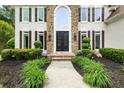 Elegant front entrance featuring a stone facade, arched window, and wrought iron double doors at 1008 Stream Valley Ct, Alpharetta, GA 30022