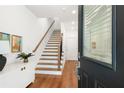 Bright entryway featuring hardwood floors, staircase with wooden railing, and modern decor at 1032 Robert Smalls Way, Atlanta, GA 30318