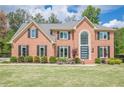 Charming brick home with a manicured lawn, dark shutters, and beautiful landscaping for great curb appeal at 10610 Kingsmark Trl, Alpharetta, GA 30022