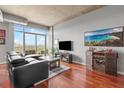 Bright living room featuring a comfortable black sofa, wooden floors, bar cabinet, and beautiful cityscape views at 250 Pharr Ne Rd # 1914, Atlanta, GA 30305